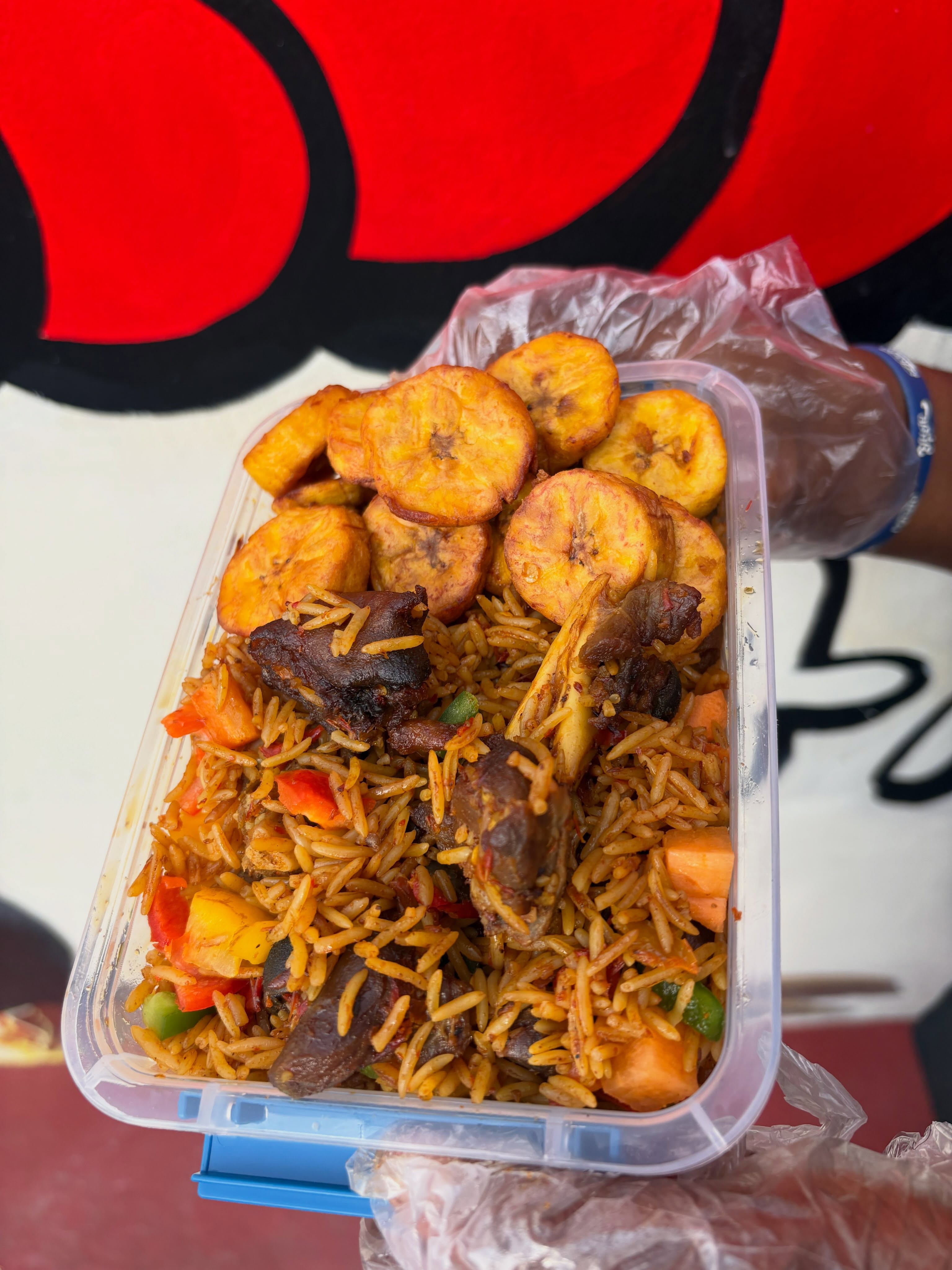 Bellefood's Asun jollof with plantain, photographed in a takeaway container